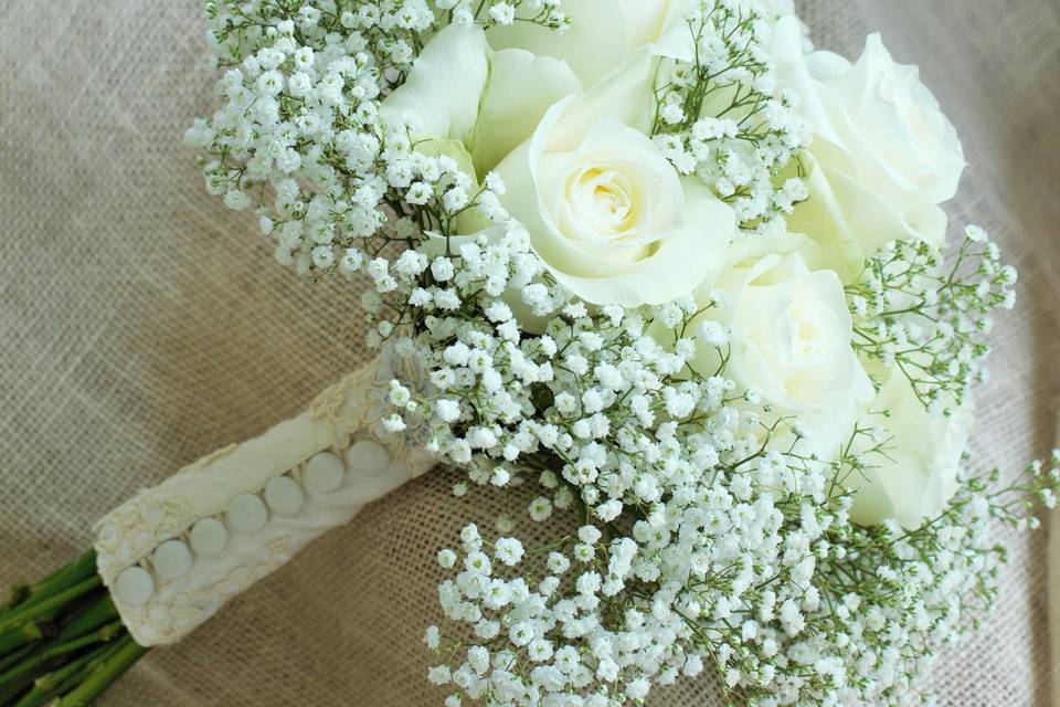Classic baby's breath and roses.  Mother of the brides material from her wedding dress was used to the handle treatment.