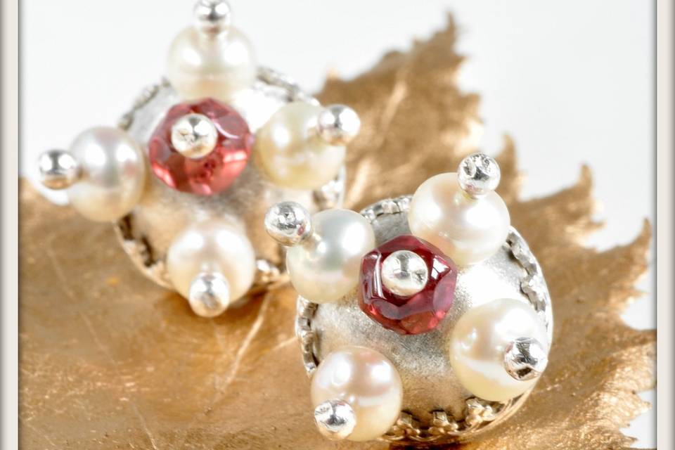 Aphrodite Stud Earrings in White Pearl and Garnet - Inspired by medieval architectural motifs, these earrings feature tiny white pearls and deep red faceted garnets mounted in a frosted sterling silver dome with a delicate filigree setting. Set on sterling silver posts.
