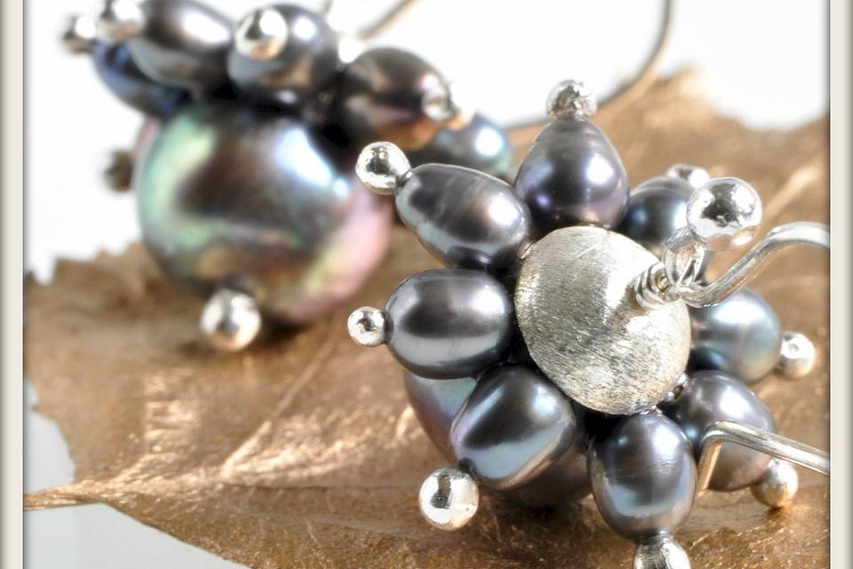 Daisy Earrings in Black Pearl - Centers of elegant black pearl buttons surrounded by petals of oval black pearls, accented by sterling silver tips with a hand-formed frosted sterling silver cap and sterling silver French ear wires.