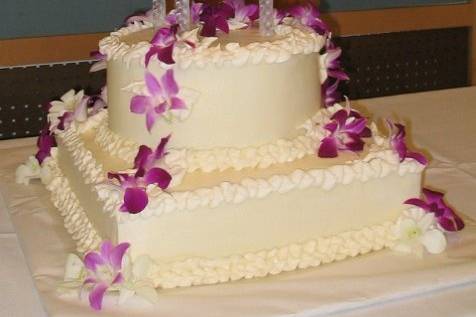 Square and rounds make up this elegantly simple wedding cake adorned with fresh orchids
