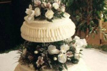 This was the first wedding cake I ever baked! It is four tiers and each tier usdecorated with two overlapping rows of icing ruffles. The flavor was lemon, the year was 1993 and the bride and her family are still ordering lemon cakes from me