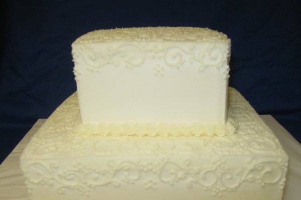 This is a square two tiered ebroidery decorated cake.