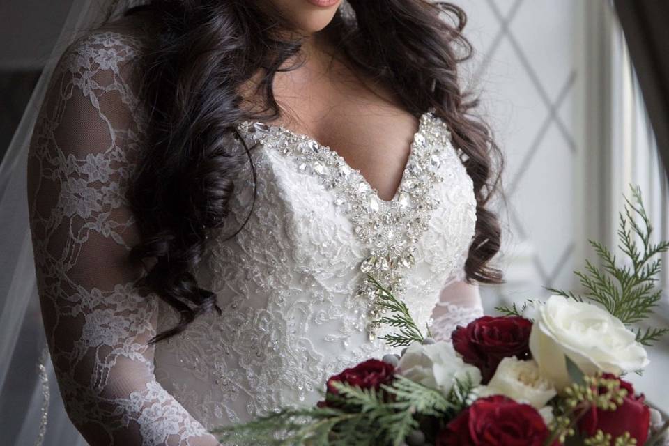 Bride in her makeup and in a sleeved lace wedding dress