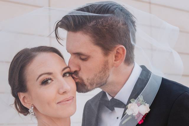 Groom kissing bride on cheek