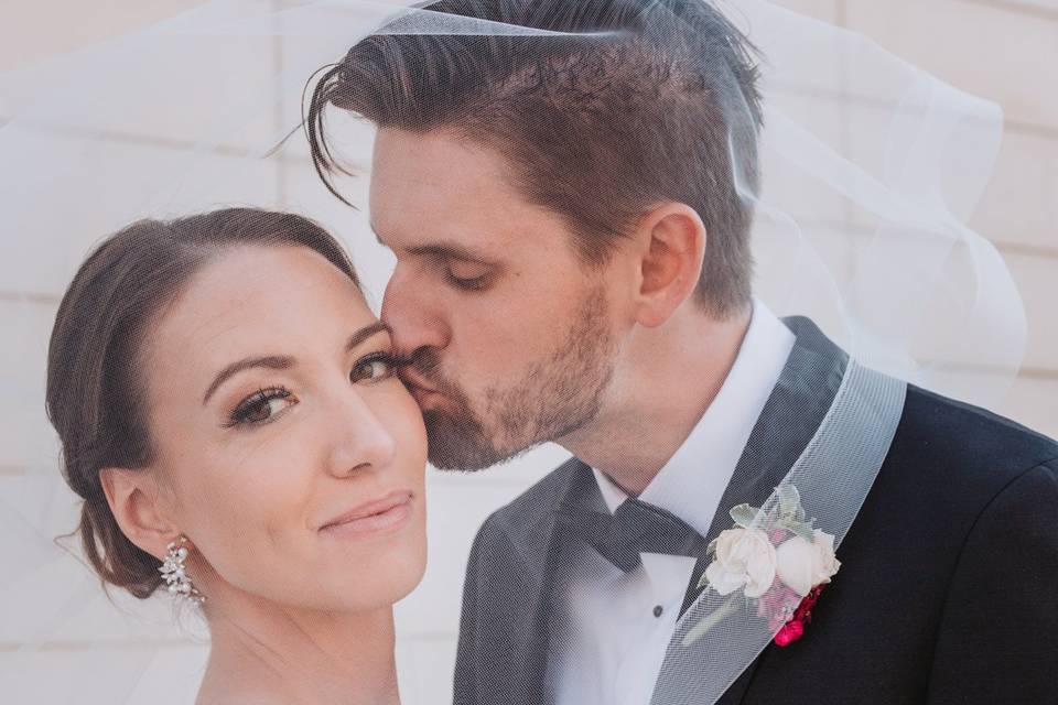 Groom kissing bride on cheek