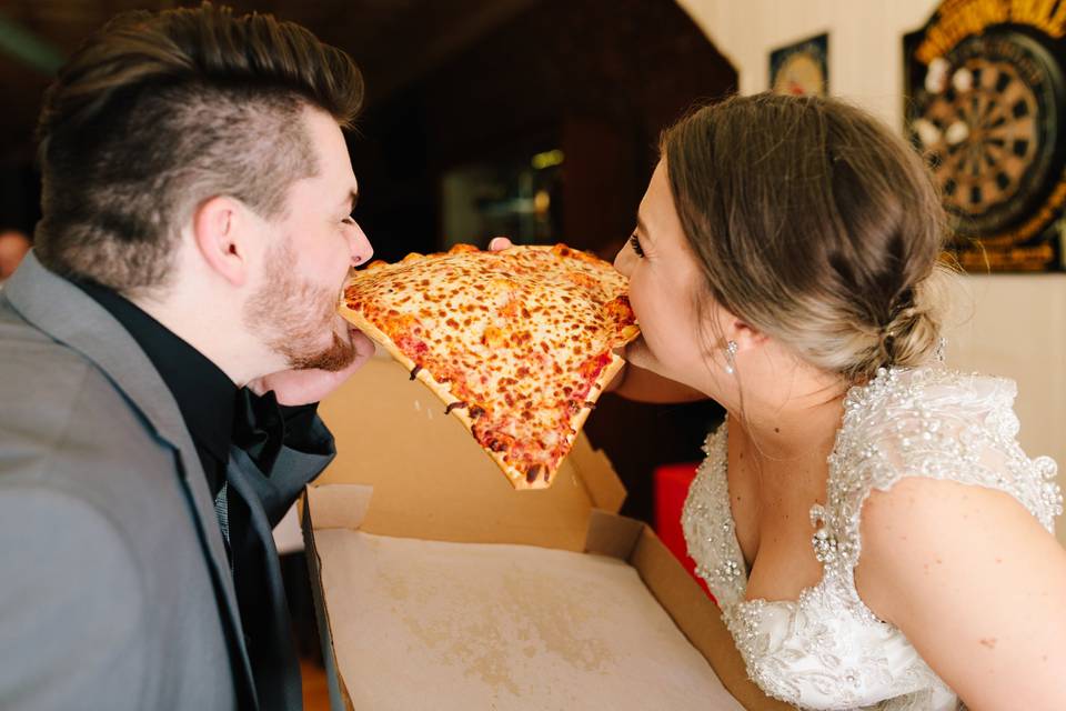 Bride and groom eating pizza