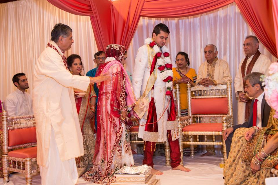 Happily married couple decorated with flowers and garland  at the Wyndham Anaheim Garden Grove during the saat pheras