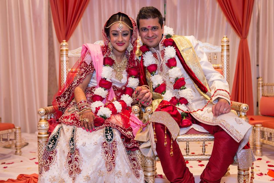 Happily married couple decorated with flowers and garland  at the Wyndham Anaheim Garden Grove