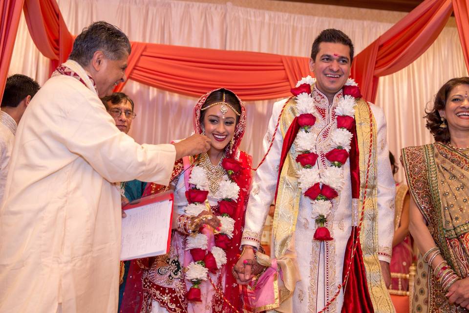 Happily married couple decorated with flowers and garland  at the Wyndham Anaheim Garden Grove