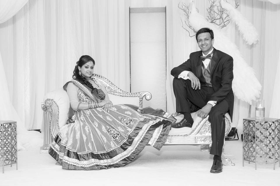 Beautiful bride and dashing groom in Indian wedding and reception outfits, poses for photos