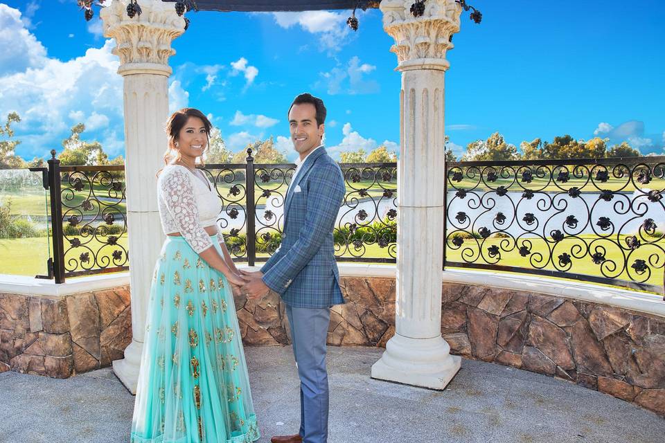 Beautiful bride and dashing groom in Indian wedding and reception outfits, poses for photos
