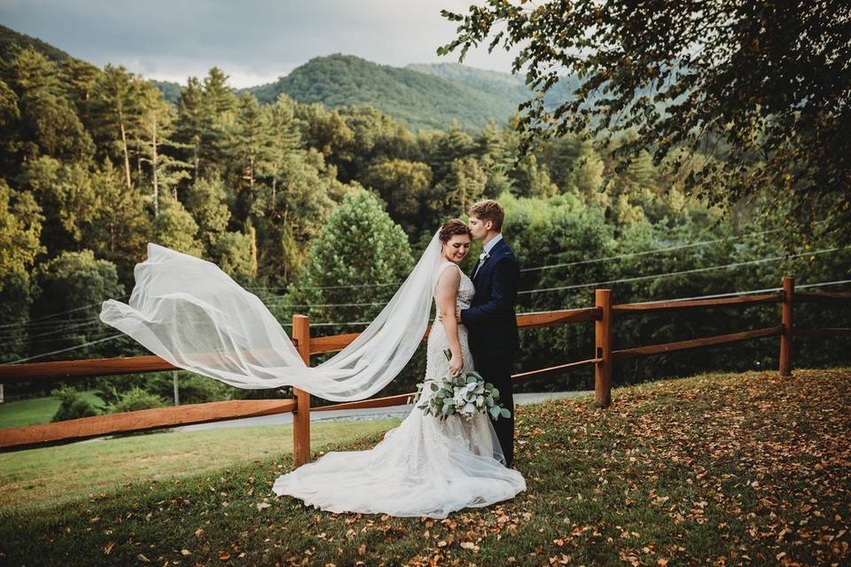 Couple standing before the trees and fence