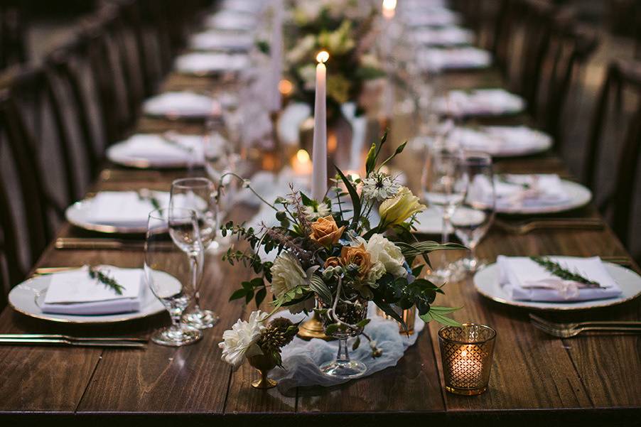 wedding details of plates, flowers, and rustic tables.