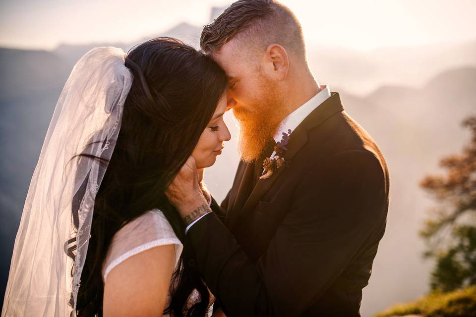 Wedding couple enjoying the sunset photos in the mountains.