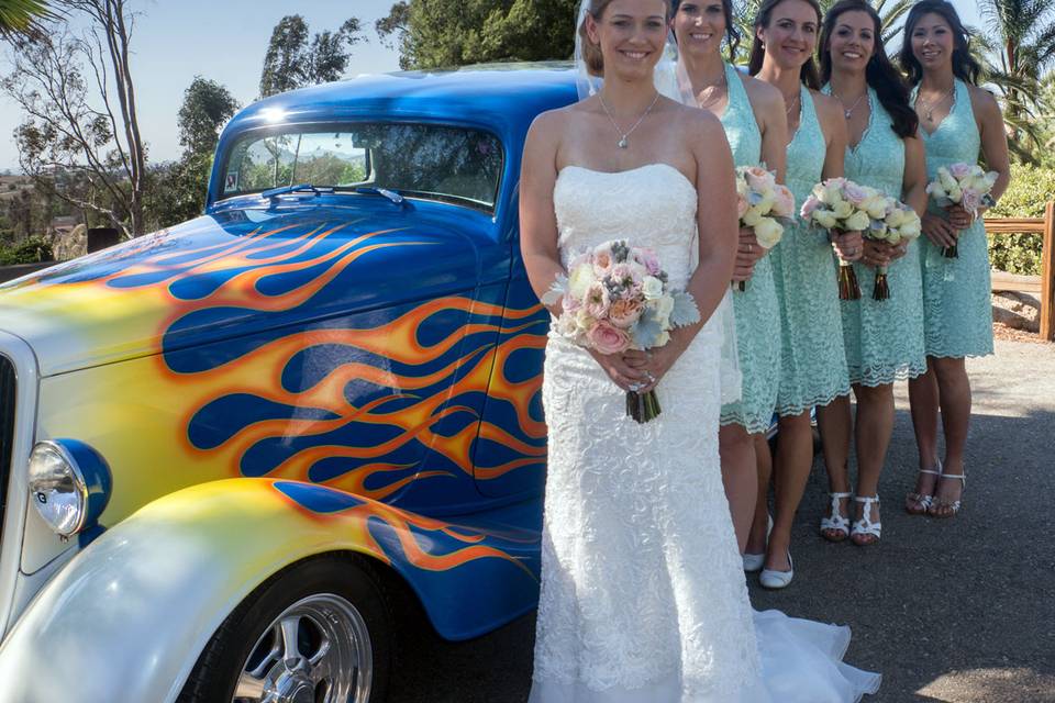 Bridal party with custom car on estate grounds