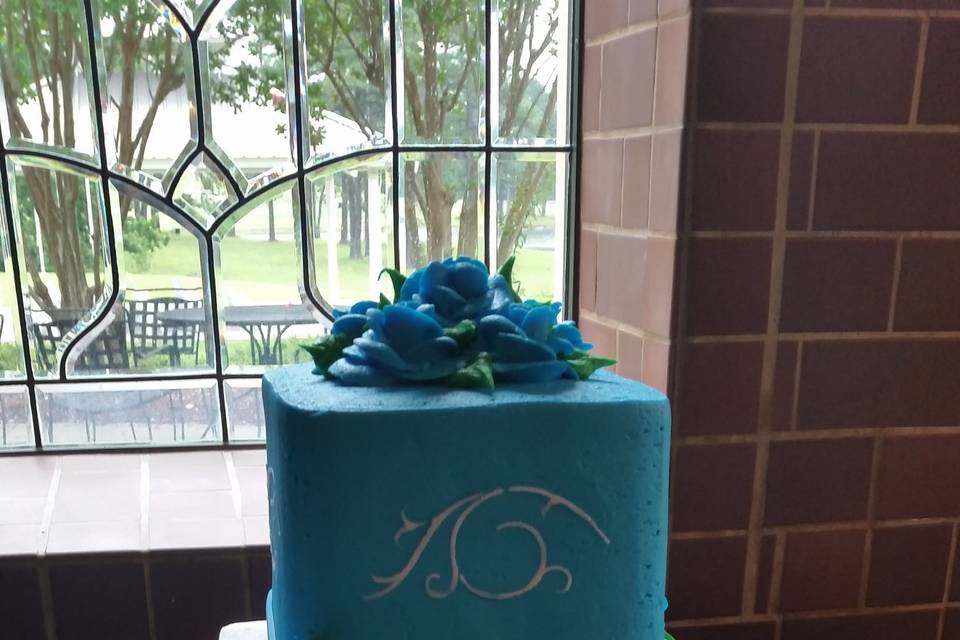 Three-tier square cake, all buttercream, in aqua and white.