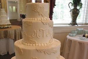 Fondant lace and monogramming embellish a buttercream cake at the McCutcheon House on USC campus.