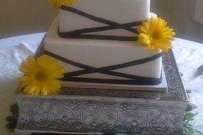 Fresh gerbera daisies and black ribbons give this elegant cake contemporary appeal.