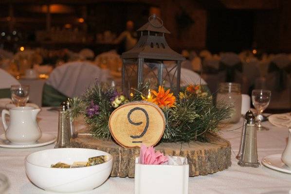 Wood slabs with black lanterns and greenery. Wood burned table numbers.