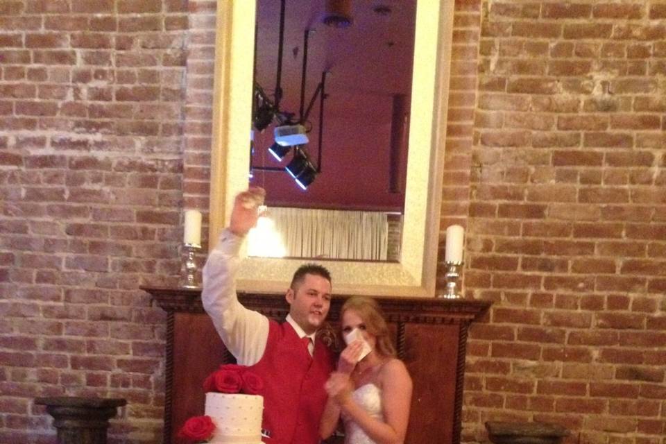 Smashing of the cake! Cake table in front of fireplace in main ballroom. The cake stand is one of many we have for our clients to use.